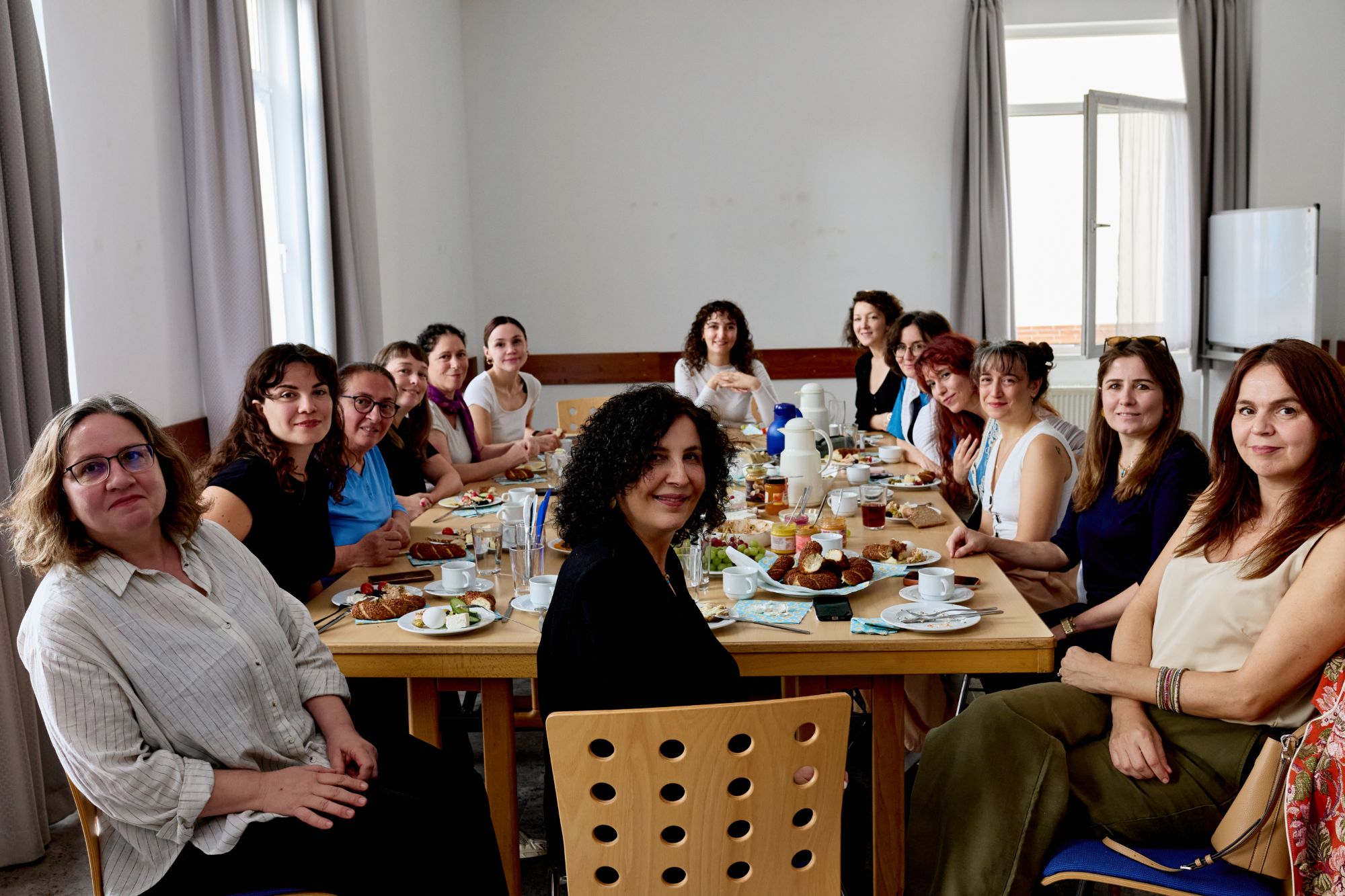 Frauen von mifem e.V. beim gemeinsamen Frühstück an einem langen Tisch